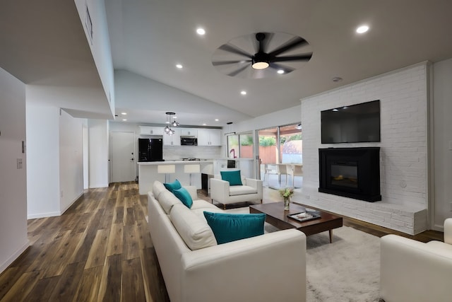 living room featuring a brick fireplace, ceiling fan, sink, wood-type flooring, and lofted ceiling