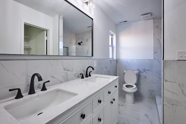 bathroom featuring walk in shower, vanity, tile walls, and toilet