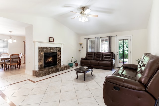 tiled living room with a premium fireplace, ceiling fan with notable chandelier, and lofted ceiling