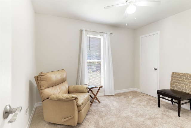 living area featuring light carpet and ceiling fan