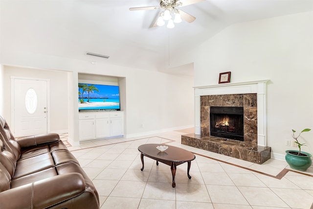 living room featuring vaulted ceiling, light tile patterned floors, and ceiling fan