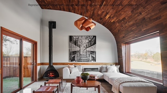 living room featuring a wood stove, a wealth of natural light, and high vaulted ceiling