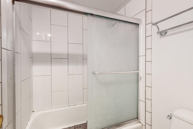 bathroom featuring shower / bath combination with glass door and toilet