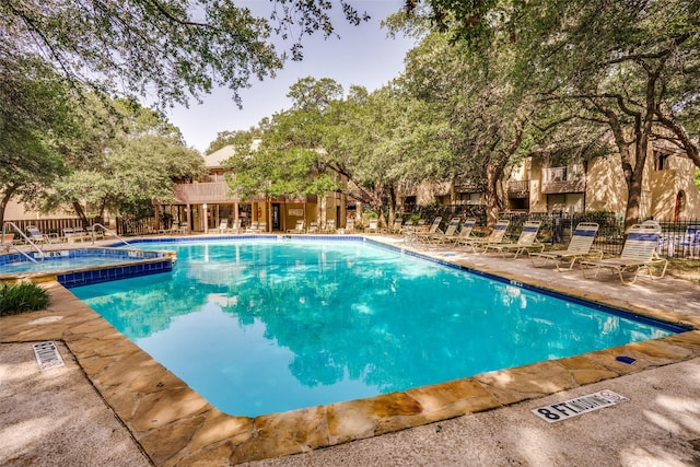 view of swimming pool featuring a patio area and a hot tub