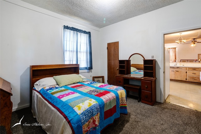 carpeted bedroom featuring an inviting chandelier, connected bathroom, sink, and a textured ceiling