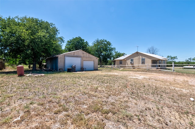 view of yard with a garage and an outbuilding