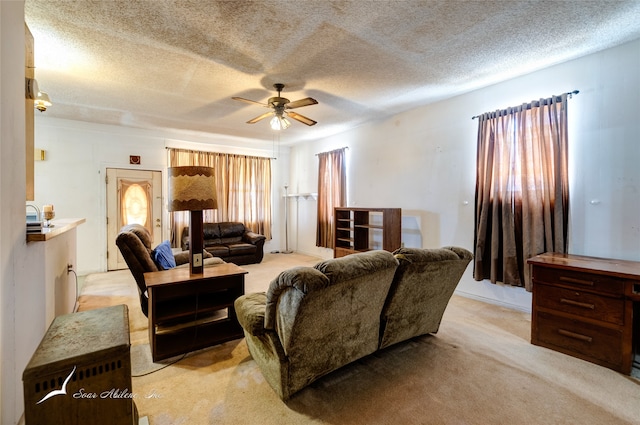 living room with a textured ceiling, ceiling fan, and light colored carpet