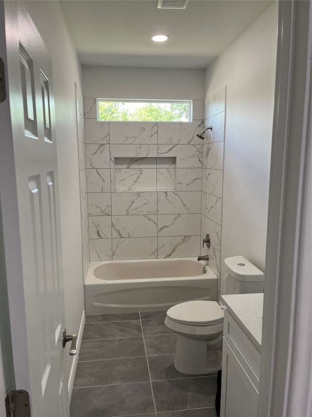 full bathroom featuring tile patterned floors, vanity, tiled shower / bath combo, and toilet