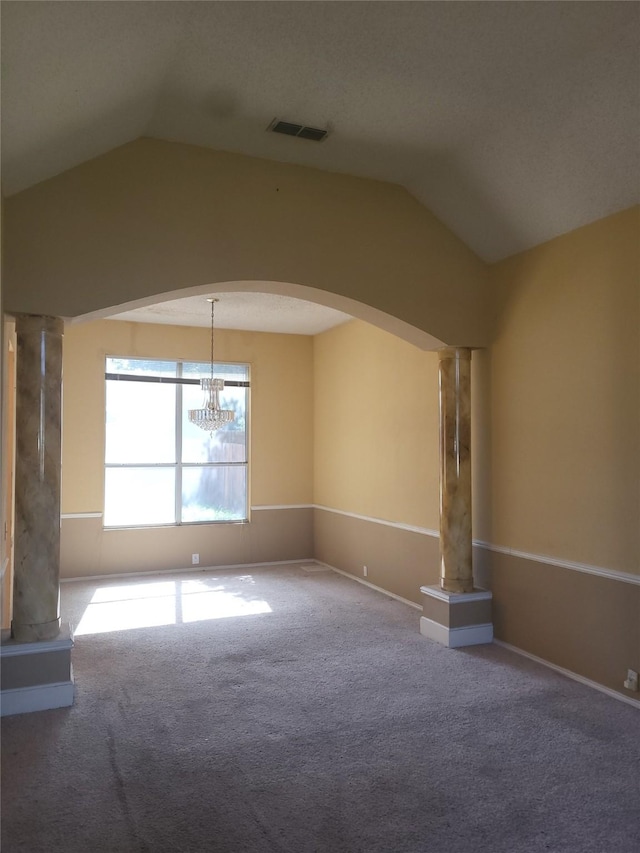 spare room with a chandelier, carpet floors, and vaulted ceiling