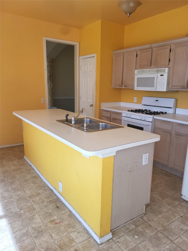 kitchen with light brown cabinetry, an island with sink, white appliances, and sink