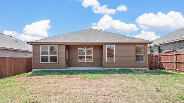 rear view of house featuring a yard and a patio