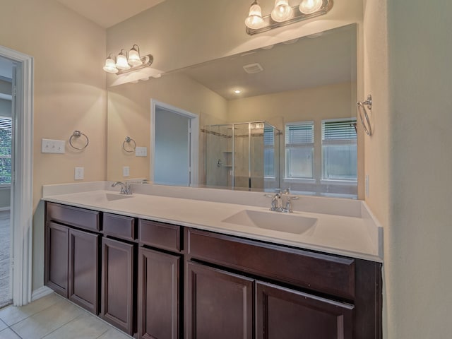 bathroom with a wealth of natural light, tile patterned floors, walk in shower, and dual bowl vanity