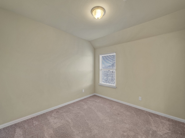 empty room with carpet and vaulted ceiling