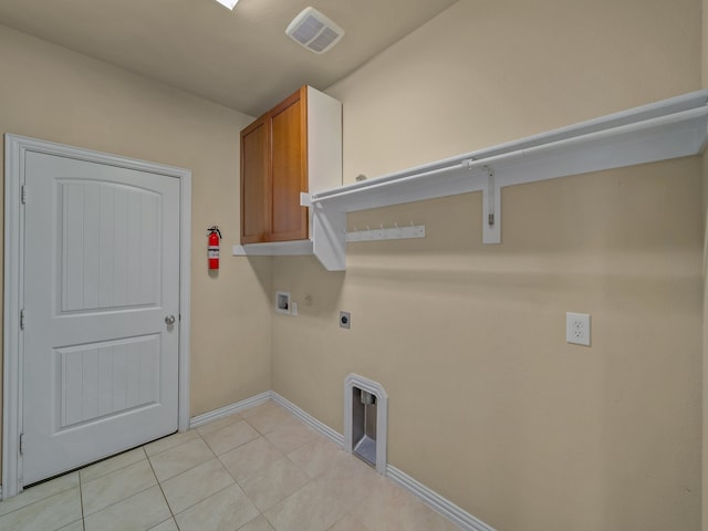 laundry room with cabinets, hookup for a washing machine, hookup for an electric dryer, and light tile patterned floors