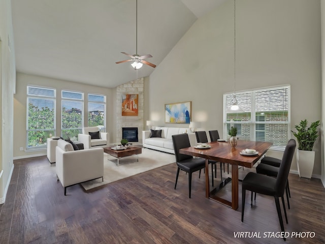 dining room with high vaulted ceiling, a fireplace, ceiling fan, and dark hardwood / wood-style floors