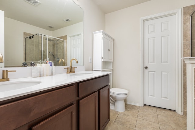 bathroom featuring tile patterned flooring, vanity, toilet, and a shower with door