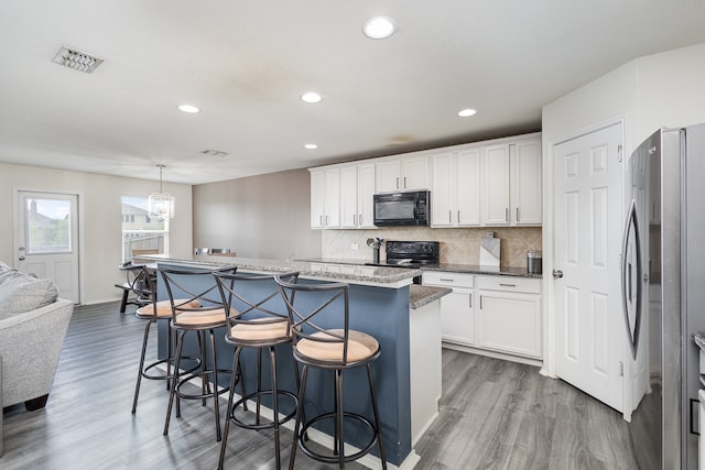 kitchen featuring a center island, pendant lighting, white cabinets, and black appliances