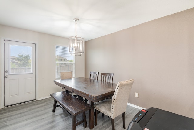 dining space featuring light hardwood / wood-style floors and an inviting chandelier