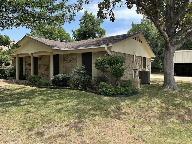 ranch-style home with a front lawn and central air condition unit