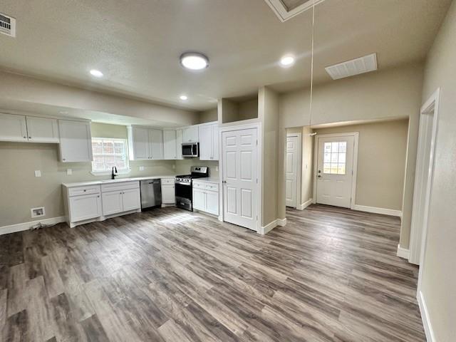 kitchen with white cabinetry, appliances with stainless steel finishes, sink, and light wood-type flooring