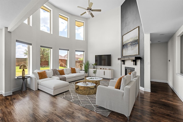 living room with plenty of natural light, ceiling fan, dark hardwood / wood-style flooring, and a fireplace