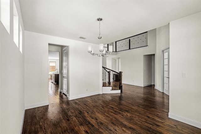 unfurnished dining area featuring a notable chandelier and dark hardwood / wood-style flooring