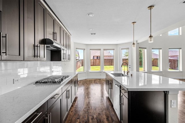 kitchen featuring stainless steel appliances, an island with sink, hanging light fixtures, and sink