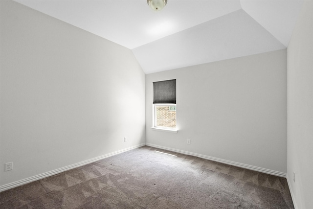 empty room featuring carpet and lofted ceiling