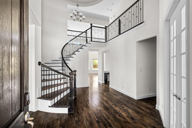 entrance foyer with a chandelier, a high ceiling, and dark hardwood / wood-style floors