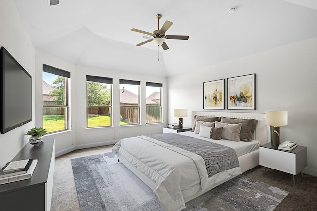 bedroom featuring dark colored carpet, vaulted ceiling, and ceiling fan