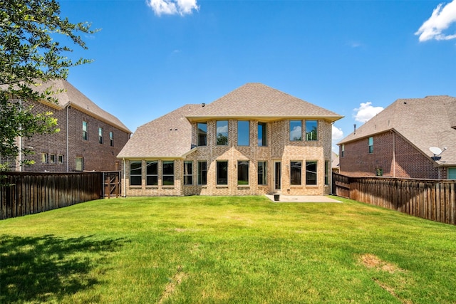 back of property with a lawn and a patio