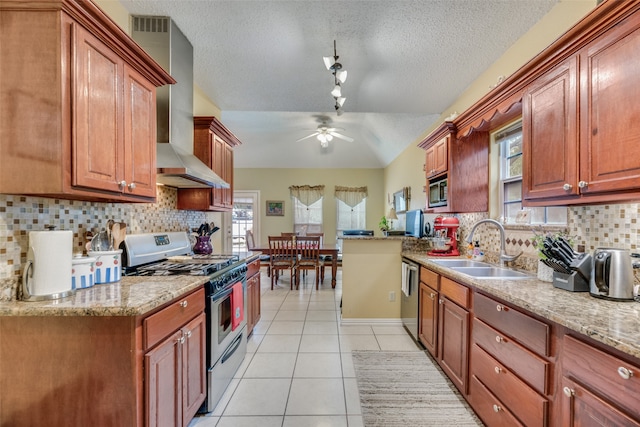 kitchen featuring stainless steel appliances, wall chimney range hood, backsplash, a textured ceiling, and ceiling fan