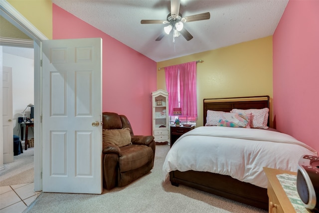 carpeted bedroom featuring a textured ceiling, vaulted ceiling, and ceiling fan