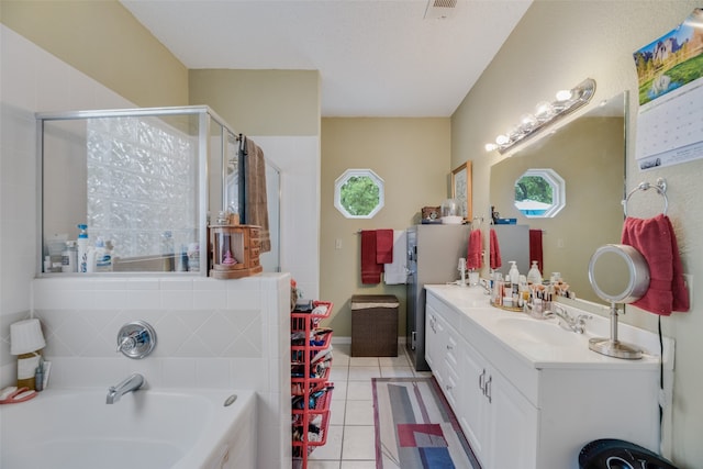 bathroom featuring tile patterned flooring, shower with separate bathtub, and vanity