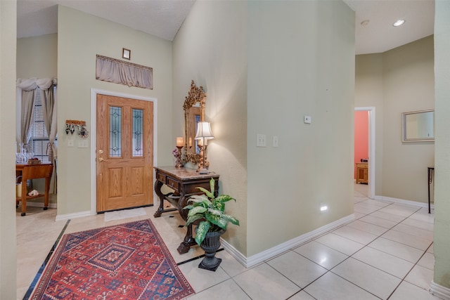 tiled entryway featuring a towering ceiling