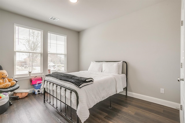 bedroom with dark hardwood / wood-style flooring and multiple windows