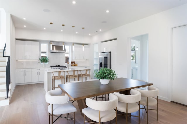 dining area with sink, a wealth of natural light, and light wood-type flooring