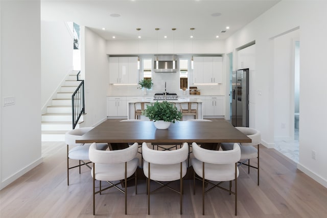 dining space featuring sink and light wood-type flooring