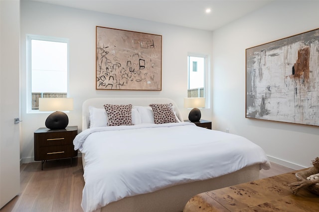 bedroom with multiple windows and wood-type flooring