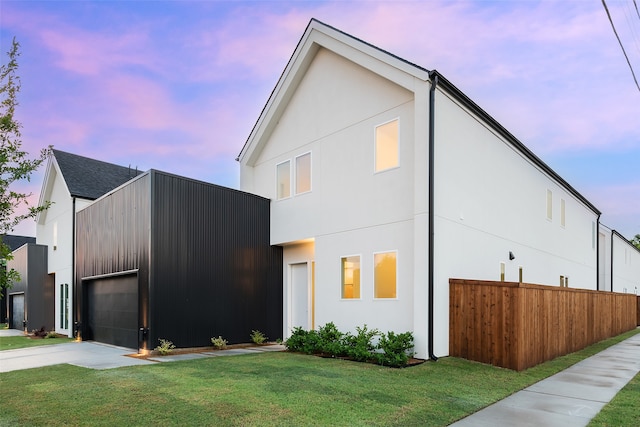 contemporary house featuring a garage and a lawn