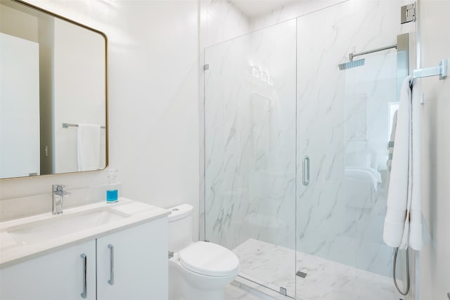 bathroom featuring a shower with shower door, vanity, and toilet