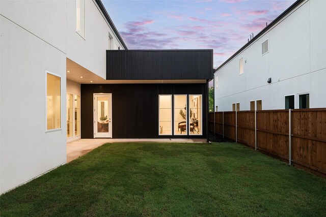 back house at dusk with a yard