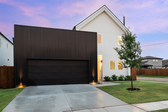 contemporary home featuring a garage and a lawn