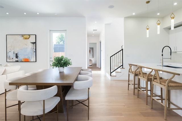 dining area with sink and light wood-type flooring