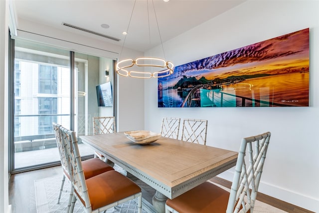 dining area featuring light wood-type flooring and an inviting chandelier