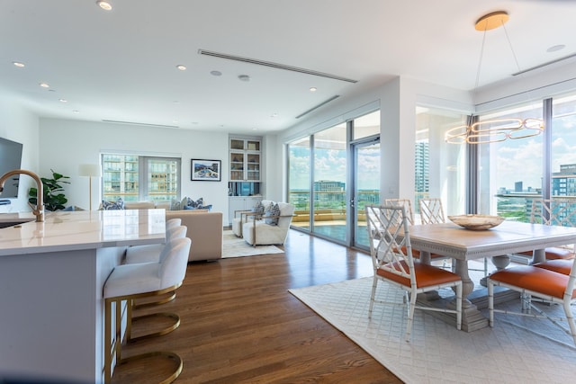 dining room with sink, an inviting chandelier, and dark hardwood / wood-style floors