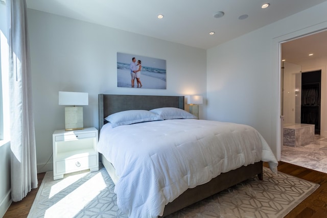 bedroom featuring connected bathroom and hardwood / wood-style floors