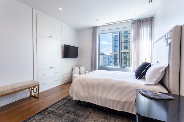 bedroom with dark hardwood / wood-style floors