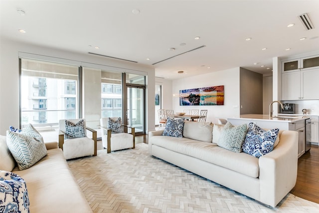 living room featuring sink and light hardwood / wood-style floors