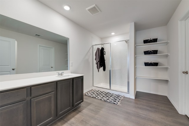 bathroom with hardwood / wood-style floors, an enclosed shower, and vanity